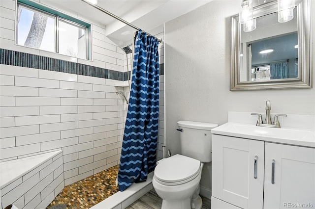 6948 W 70th Ave, Arvada, CO 80003 - full bathroom featuring vanity, toilet, and tiled shower