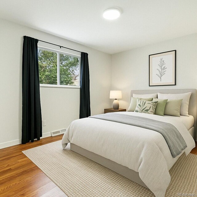 6948 W 70th Ave, Arvada, CO 80003 - bedroom featuring wood finished floors and baseboards
