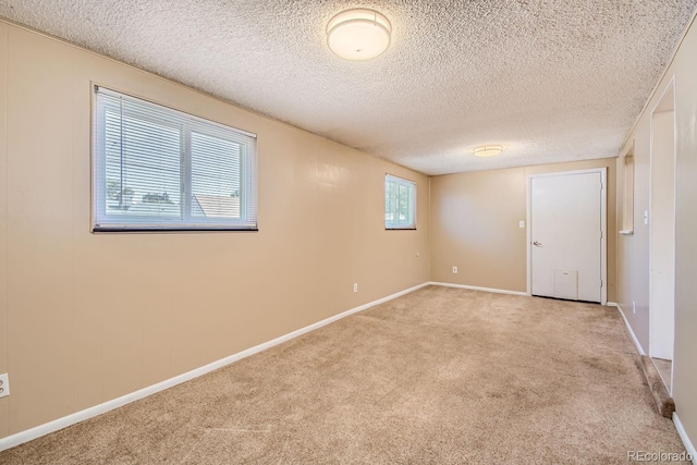 empty room featuring light carpet and a textured ceiling