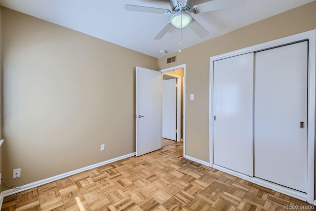 unfurnished bedroom with ceiling fan, a closet, and light parquet floors