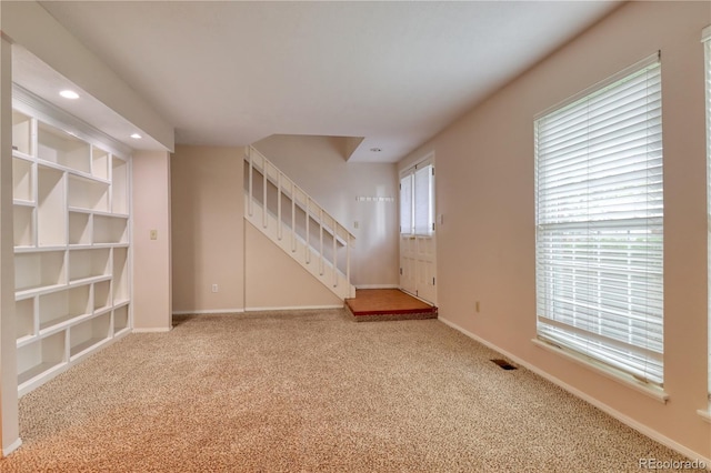 10320 E Jewell Ave Unit 63, Aurora, CO 80247 - unfurnished living room featuring stairway, carpet flooring, baseboards, healthy amount of natural light, and recessed lighting