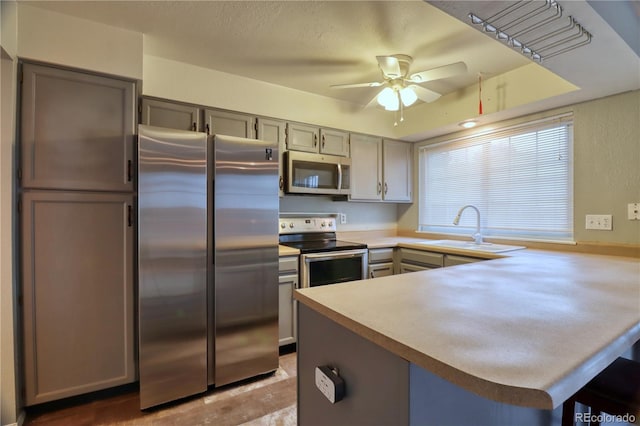 10320 E Jewell Ave Unit 63, Aurora, CO 80247 - kitchen with stainless steel appliances, a sink, gray cabinetry, a peninsula, and ceiling fan