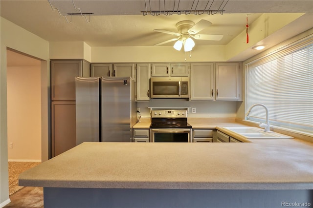 10320 E Jewell Ave Unit 63, Aurora, CO 80247 - kitchen featuring appliances with stainless steel finishes, a sink, light countertops, a ceiling fan, and a peninsula