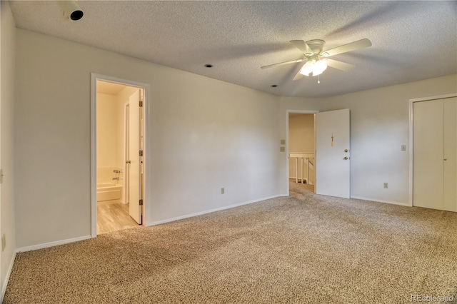 10320 E Jewell Ave Unit 63, Aurora, CO 80247 - unfurnished bedroom with light colored carpet, baseboards, a textured ceiling, ensuite bath, and ceiling fan