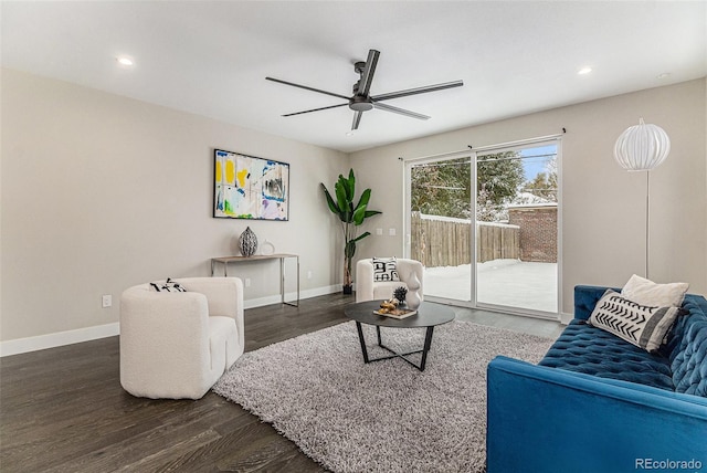 living room featuring dark wood-type flooring and ceiling fan