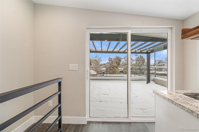 doorway featuring dark hardwood / wood-style flooring and lofted ceiling