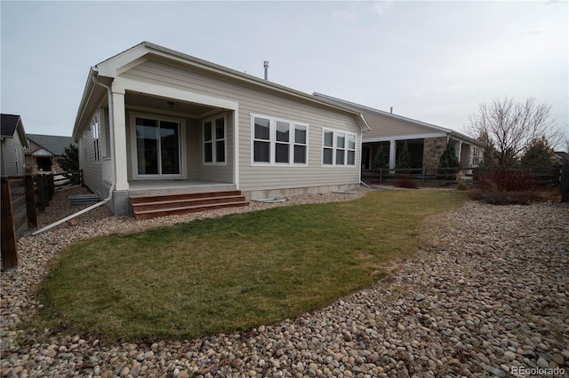 rear view of property with a yard and fence