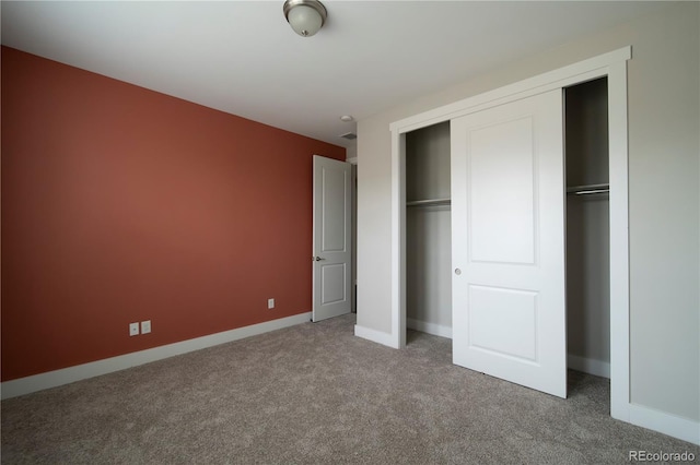 unfurnished bedroom with carpet floors, baseboards, and a closet