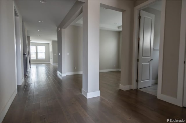 hall featuring dark wood-style floors and baseboards