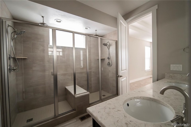 full bath featuring a healthy amount of sunlight, a shower stall, and a sink