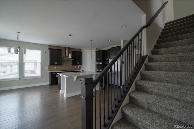 stairway with recessed lighting, baseboards, and wood finished floors