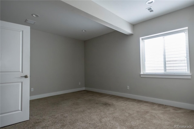 carpeted spare room featuring beamed ceiling, visible vents, and baseboards