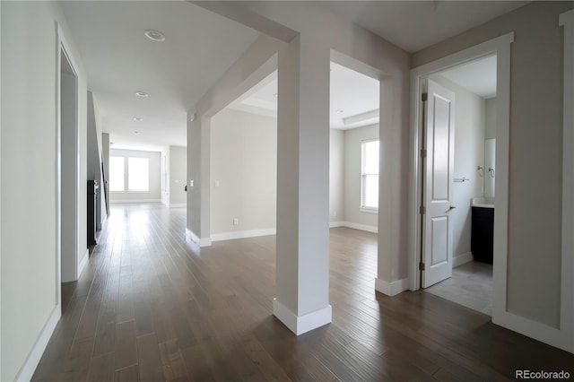 hallway with baseboards and dark wood-style floors