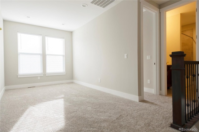 carpeted empty room featuring visible vents and baseboards