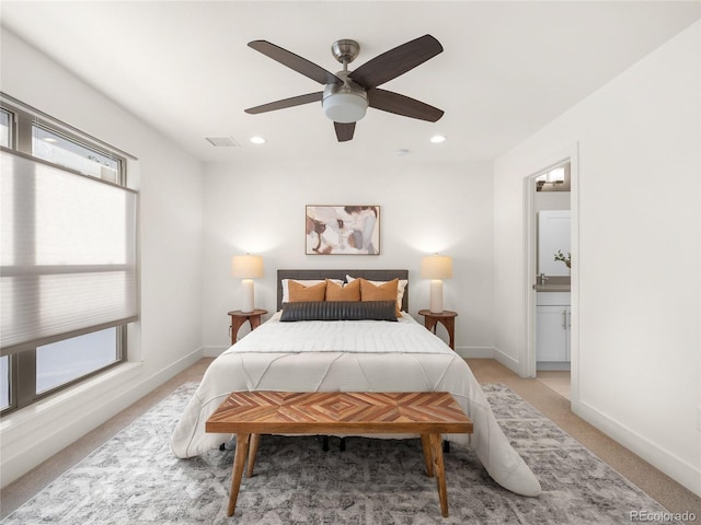 carpeted bedroom with connected bathroom and ceiling fan