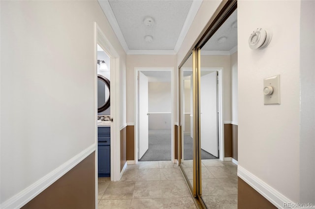 hallway with crown molding and baseboards
