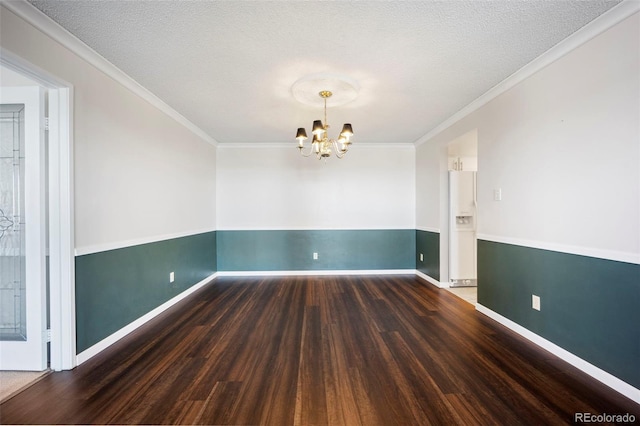 spare room featuring a chandelier, crown molding, baseboards, and wood finished floors