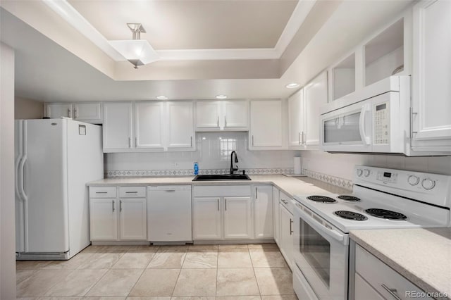 kitchen featuring a sink, a tray ceiling, white cabinets, white appliances, and light countertops