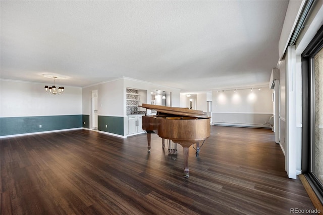game room featuring baseboard heating, a textured ceiling, ornamental molding, an inviting chandelier, and dark wood-type flooring