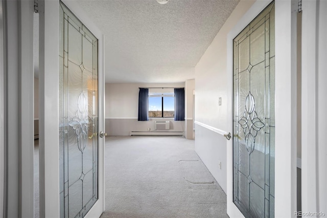 corridor with a textured ceiling, baseboard heating, and carpet