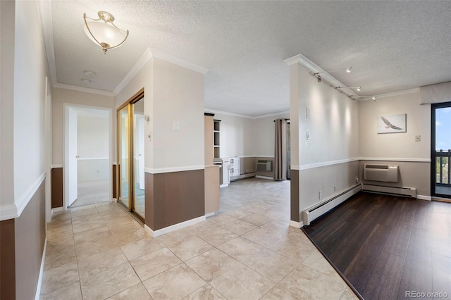 foyer entrance featuring a textured ceiling, ornamental molding, a wall mounted AC, tile patterned floors, and rail lighting