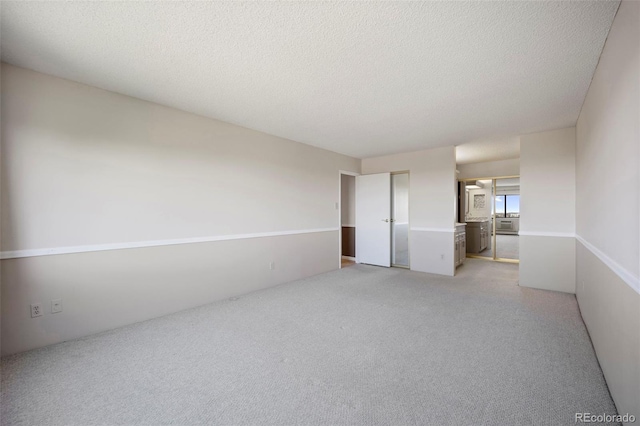 unfurnished room with light carpet and a textured ceiling