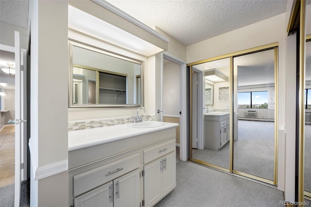 bathroom with a textured ceiling, tasteful backsplash, and vanity