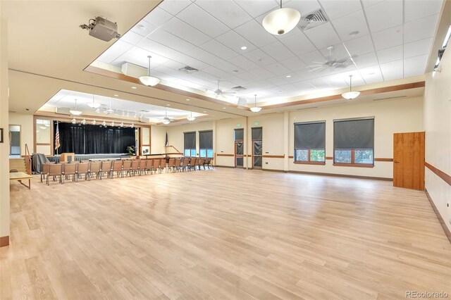 workout area featuring ceiling fan, wood finished floors, a drop ceiling, and baseboards