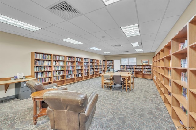 sitting room with bookshelves and a paneled ceiling