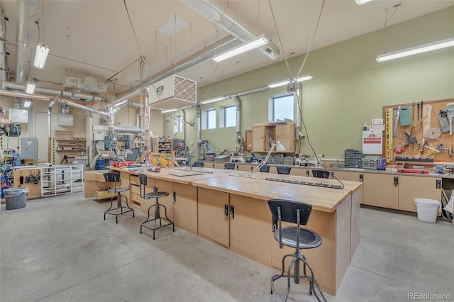 miscellaneous room with a workshop area and concrete floors