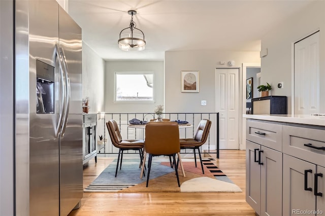 dining room with light hardwood / wood-style flooring and a notable chandelier