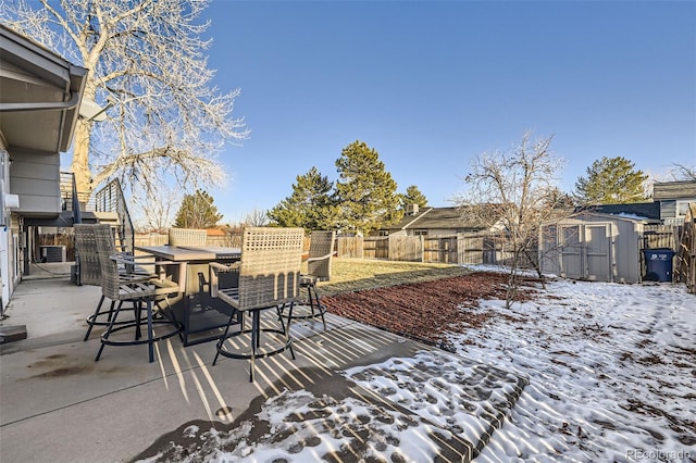 snow covered patio with a storage unit