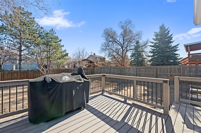 wooden deck with a fenced backyard and grilling area