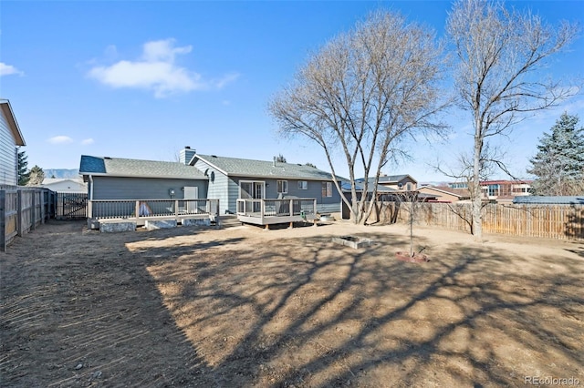 back of house with a chimney, a fenced backyard, and a deck