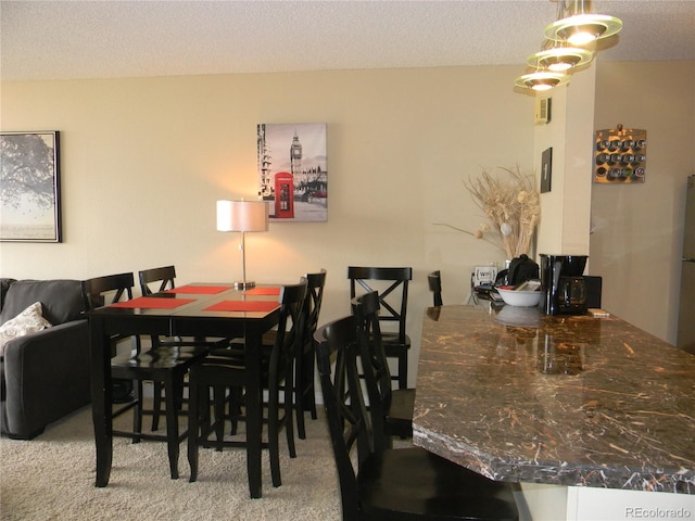 dining space with carpet and a textured ceiling