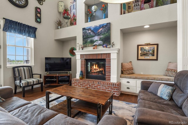 3973 Palmer Ridge Dr, Parker, CO 80134 - living area featuring a brick fireplace, wood finished floors, and a towering ceiling