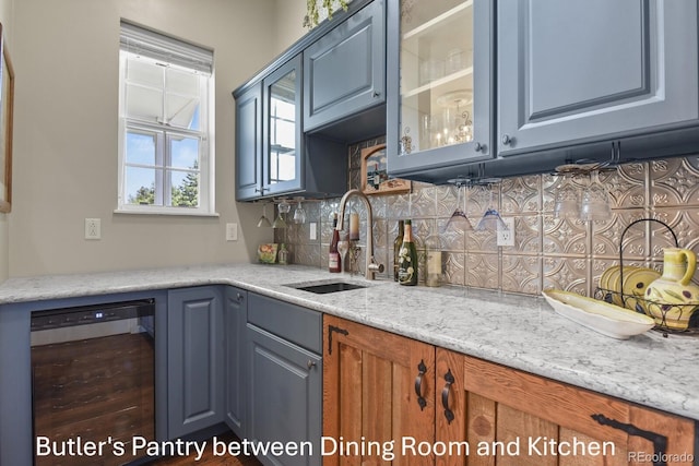 3973 Palmer Ridge Dr, Parker, CO 80134 - kitchen with beverage cooler, glass insert cabinets, backsplash, and light stone countertops