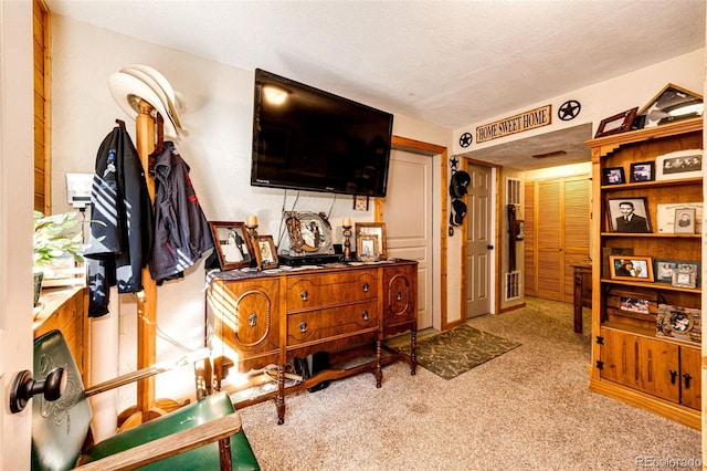 interior space featuring light carpet and a textured ceiling