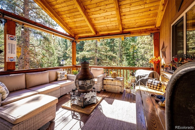 sunroom / solarium with wood ceiling, a healthy amount of sunlight, and lofted ceiling with beams