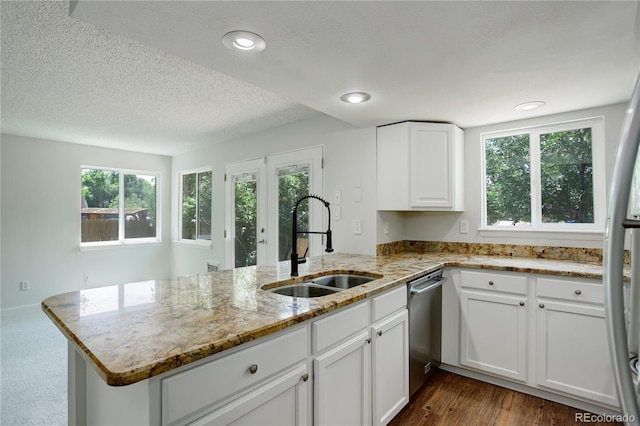 5163 E 123rd Ct, Thornton, CO 80241 - kitchen with a peninsula, appliances with stainless steel finishes, white cabinets, healthy amount of natural light, and a textured ceiling
