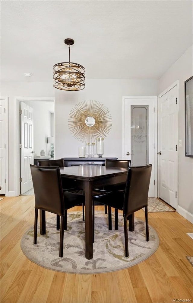 dining area with a chandelier and light hardwood / wood-style flooring