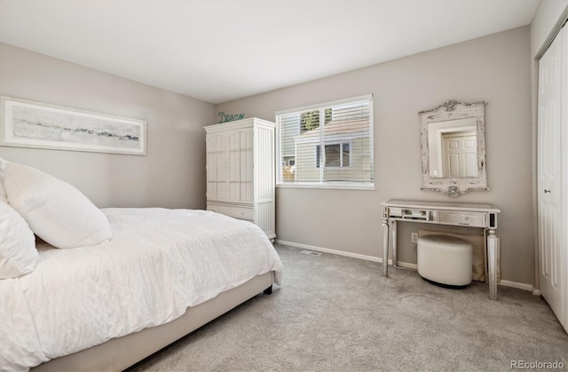 bedroom featuring light carpet and a closet