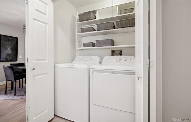 washroom featuring washing machine and dryer and light hardwood / wood-style floors