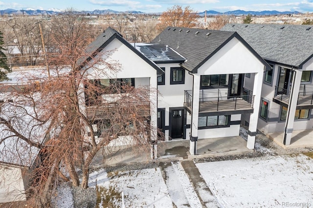 view of front of house with a mountain view and a balcony