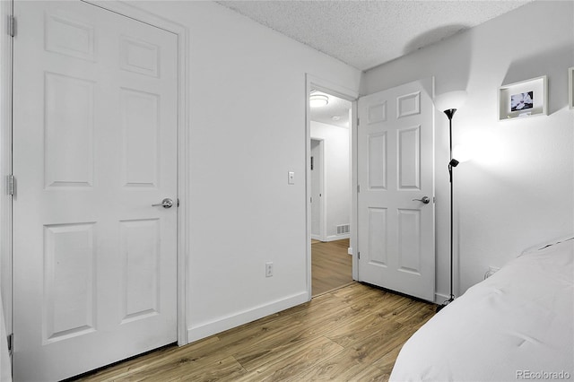 17499 E Whitaker Dr, Aurora, CO 80015 - bedroom featuring a textured ceiling, wood finished floors, and baseboards