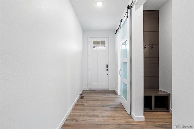 entryway featuring light wood-type flooring and a barn door