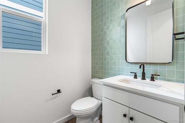 bathroom with tasteful backsplash, toilet, vanity, and tile walls