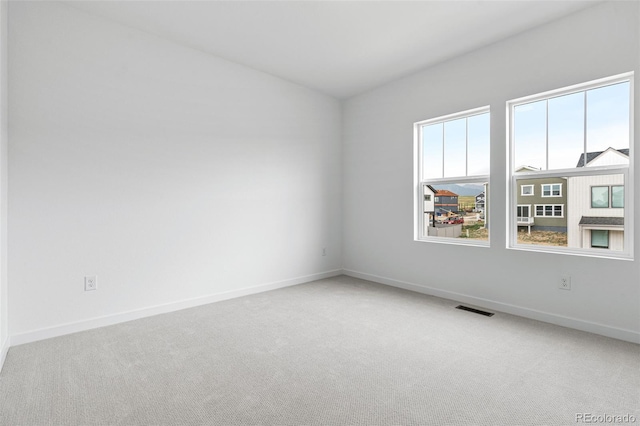 unfurnished room featuring light colored carpet