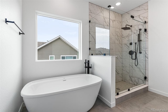 bathroom with a wealth of natural light, independent shower and bath, and tile patterned flooring