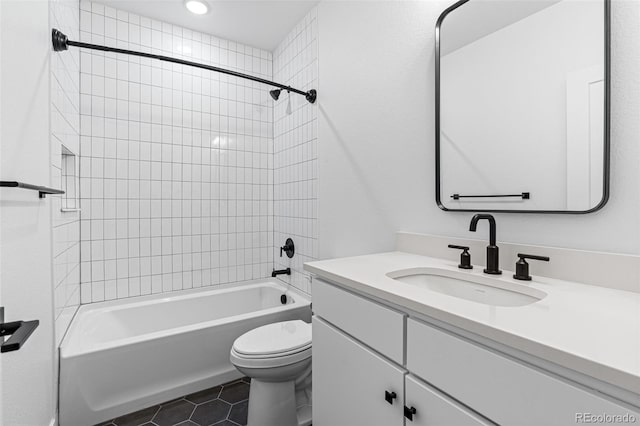 full bathroom featuring tile patterned flooring, toilet, tiled shower / bath combo, and vanity